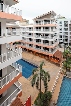 A multi-story hotel with balconies, a swimming pool, and a courtyard.