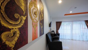 A hotel reception area with a modern design, featuring a large decorative wall, a reception desk, and a seating area.