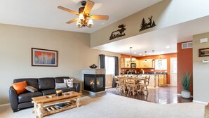 Una sala de estar amplia con chimenea, un comedor y una cocina con armarios de madera.