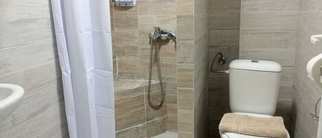 Un baño con ducha, inodoro y lavabo.