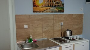 A compact kitchen with a sink, two stovetops, and a coffee maker. - SERENİTA STONE HOUSE (Rafajlovici)