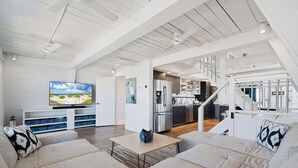 Ein modernes Wohnzimmer mit Flachbildfernseher, einer Couch und einem Couchtisch.