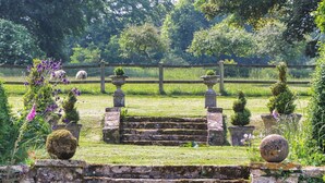 A stone staircase leading to a gate, surrounded by lush greenery and a wooden fence. - 2 bedroom accommodation in Crewkerne (Crewkerne)