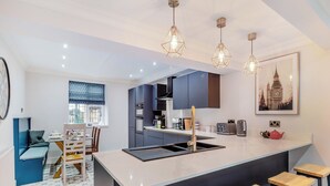 A modern kitchen with a central island, bar stools, and pendant lighting. - 5 bedroom accommodation in Chesterfield (Chesterfield)