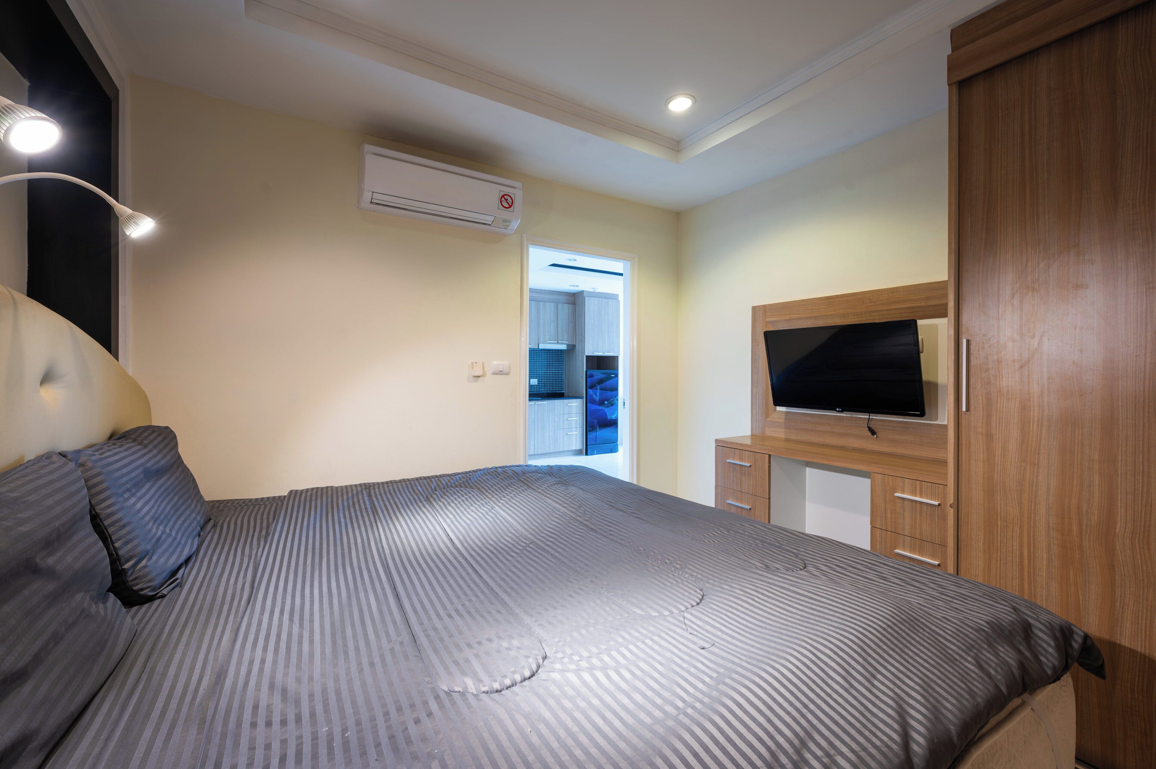 Una camera da letto con un letto, una televisione, un armadio e un condizionatore d'aria.