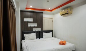 A hotel room with a bed, two bedside tables, a wardrobe, and an air conditioning unit. - New Nordic Vip 2 by Apartwell (Pattaya)