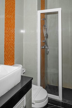 A bathroom with a white bathtub, a glass-enclosed shower, and a toilet. - New Nordic Vip 2 by Apartwell (Pattaya)