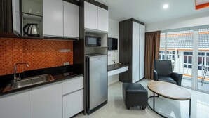 Une cuisine compacte équipée d’un four à micro-ondes, d’une bouilloire et d’un petit coin repas avec une table et des chaises.