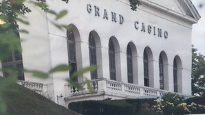 Un edificio con el letrero "Grand Casino" en su fachada, de estilo arquitectónico clásico con ventanas arqueadas y un balcón.