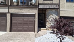 A two-story house with a garage, a balcony, and a stone facade. - nestled against the dunes, south end beach block on cul-de-sac (Brigantine)