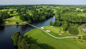 An aerial view of a golf course with a river, bridges, and surrounding greenery. - Charme Breton à 20 min de Saint-malo - 2 Chambres à 500 m du Golf du Tronchet (Le Tronchet)