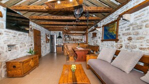 Un interior rústico con paredes de piedra, muebles de madera y una zona de cocina.