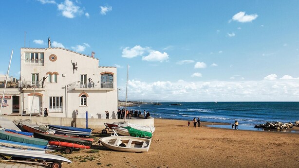 Un bâtiment situé sur la côte, doté de nombreux balcons qui donnent sur la plage.