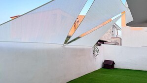 Une cour avec des murs blancs et une petite niche à chien.