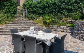 Relax in style on this serene patio, complete with a table for two and comfortable wicker chairs.