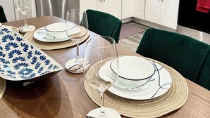 A modern kitchen with white cabinets, stainless steel appliances, and a dining area set with plates, glasses, and a decorative table runner. - City views roof deck 4B/4B -10 mins to city centre

 (Philadelphia)