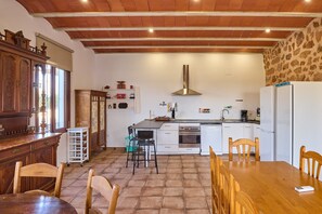 Une cuisine équipée d’une cuisinière, d’un four et de meubles de rangement blancs.