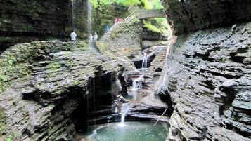 Une formation rocheuse naturelle avec une cascade et une plateforme d’observation.