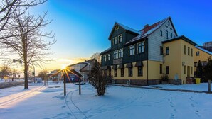 A hotel with a traditional architectural style, featuring a prominent entrance and a sign indicating the name. - Themenhotel Rehlein (Thale)