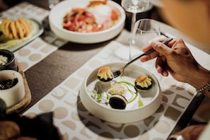 A dining table with a variety of dishes, including a plate with a dessert and a glass of wine. - Kalani Residence (Nestos)