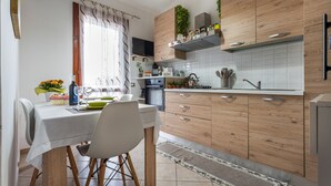 Une cuisine moderne avec des meubles en bois, une table à manger et un four encastré.