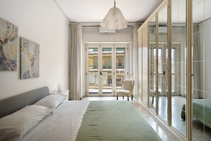 A bedroom with a bed, a chair, a large window, and a view of the outside. - Apartment 'Casa Elena' with Sea View, Wi-Fi and Air Conditioning (Salerno)