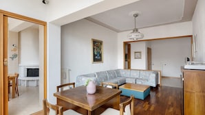 Una sala de estar con una mesa de comedor de madera, un sofá y una chimenea.