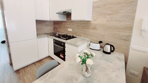 A modern kitchen with white cabinets, a gas stove, a toaster, and a kettle. - Apartment 'Special House' with Wi-Fi and Air Conditioning (Salerno)
