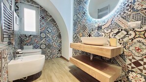 A bathroom with a white bathtub, a wooden vanity with a sink, and a tiled wall with a geometric pattern. - Apartment 'Special House' with Wi-Fi and Air Conditioning (Salerno)