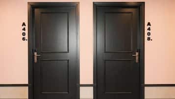 Dos puertas de color oscuro idénticas, con un número en la pared junto a cada una.
