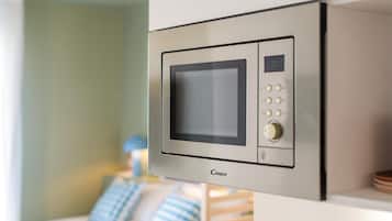 Un microondas moderno con pantalla digital y botones de control, instalado en una pared de una habitación de hotel.
