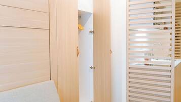 Una habitación moderna con un sofá de color claro, un armario de madera y un armario con puerta corredera de madera.