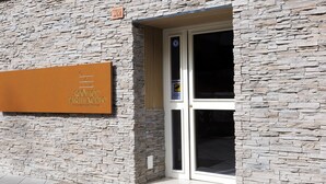 A stone facade with a sign reading "ROGETOP PARTHENOPEO" and a door with a glass panel. - Rooftop Parthenopeo - Contemporary Rooms (Naples)