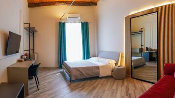 Habitación cuádruple Deluxe, balcón, vistas a la ciudad | Colchones Select Comfort, minibar con artículos gratuitos, caja fuerte