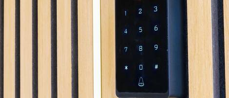 A keypad lock on a wooden panel wall.
