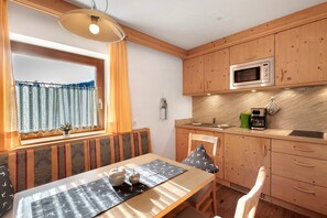 A compact kitchen with wooden cabinets, a microwave, and a coffee maker.