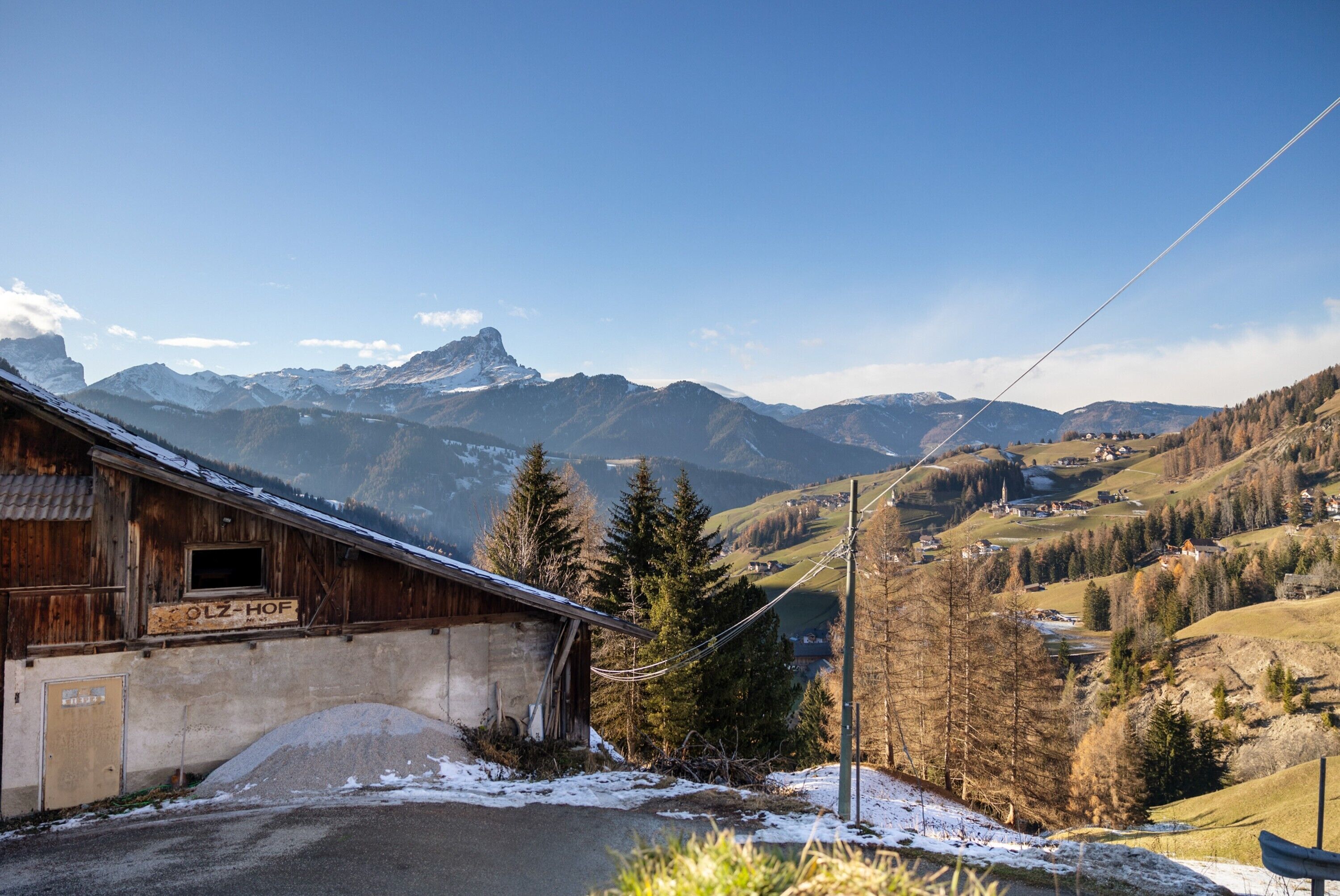 Un bâtiment en bois avec une enseigne indiquant « OLZ-HOF » et un sol recouvert de neige.