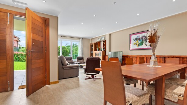 A spacious living room with a wooden dining table, comfortable seating, and a large window offering a view of the outdoors. - Country House 'Casa La Manzana' with Mountain View, Private Terrace and Wi-Fi (Villaviciosa)