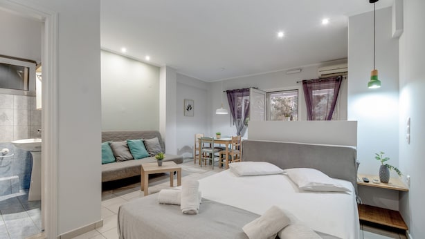 Una habitación de hotel moderna con cama, escritorio, sofá y baño.