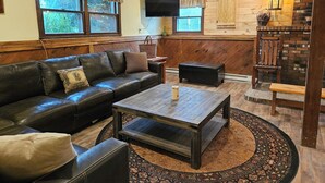 A cozy living room with a leather sofa, a wooden coffee table, and a patterned rug. - YEAR'ROUND FAMILY FUN! (Warrensburg)