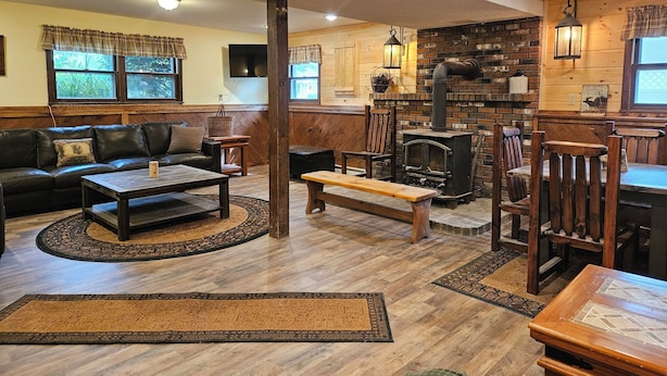A cozy living room with a fireplace, wooden furniture, and a television. - YEAR'ROUND FAMILY FUN! (Warrensburg)