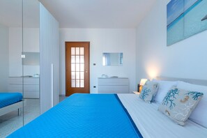 Un dormitorio con cama, armario, cómoda, espejo y puerta.