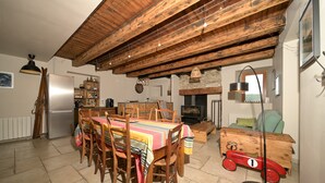 Un coin repas rustique avec une table en bois, des chaises et une voiture jouet ancienne.