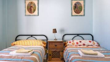 Un lit double avec une literie à rayures et une table de chevet avec une lampe.