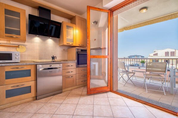 A modern kitchen with wooden cabinets, a dishwasher, an oven, and a microwave.