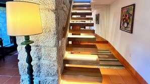 Un escalier avec des marches en bois et une lampe sur le côté gauche.