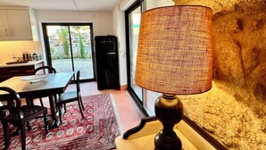 Une cuisine moderne équipée d’un réfrigérateur, d’une table à manger avec des chaises et d’un tapis.