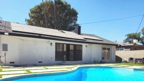 A modern house with a swimming pool, large windows, and a well-maintained lawn. - Seasun Hostel (Northridge)