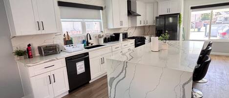 Een koelkast met diepvriezer, een microgolfoven, een oven, een kookplaat