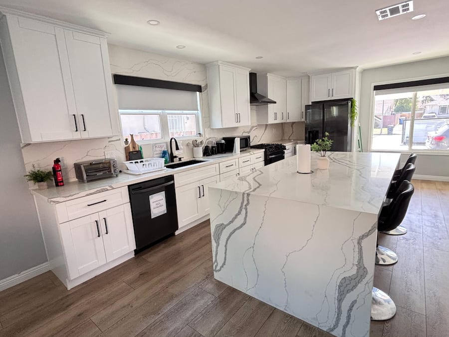 Een koelkast met diepvriezer, een microgolfoven, een oven, een kookplaat